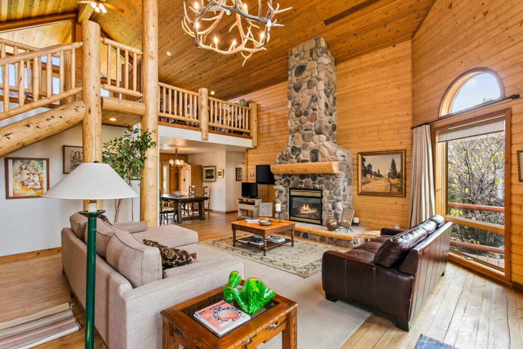Great room with a stone fireplace and timber beams